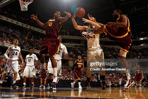 Forward Ralph Sampson III and Damian Johnson of the Minnesota Golden Gophers fight for the ball with guard D.J. Byrd of the Purdue Boilermakers in...