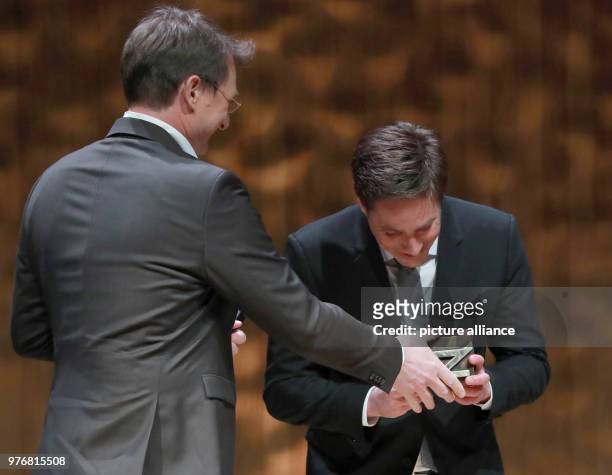 April 2018, Hamburg, Germany: Editor-in-chief of 'taz' newspaper Georg Loewisch presents Markus Feldenkirchen with his trophy. Feldenkirchen was...