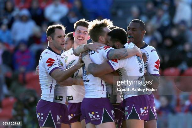 Josh Addo-Carr of the Storm celebrates his try with team mates during the round 15 NRL match between the Newcastle Knights and the Melbourne Storm at...