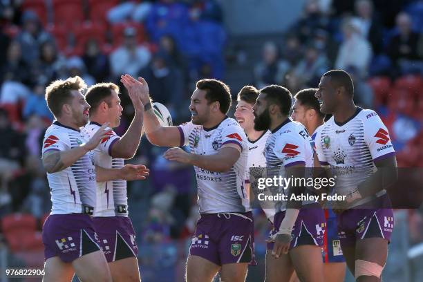 Josh Addo-Carr of the Storm celebrates his try with team mates during the round 15 NRL match between the Newcastle Knights and the Melbourne Storm at...