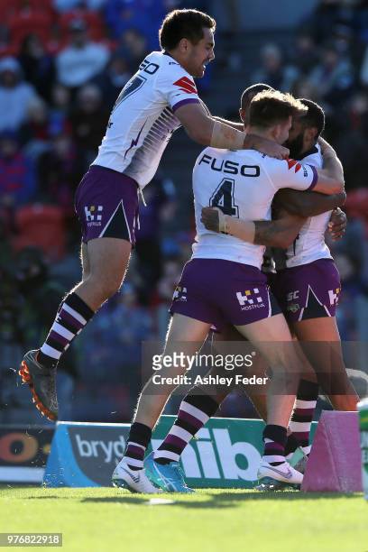 Josh Addo-Carr of the Storm celebrates his try with team mates during the round 15 NRL match between the Newcastle Knights and the Melbourne Storm at...