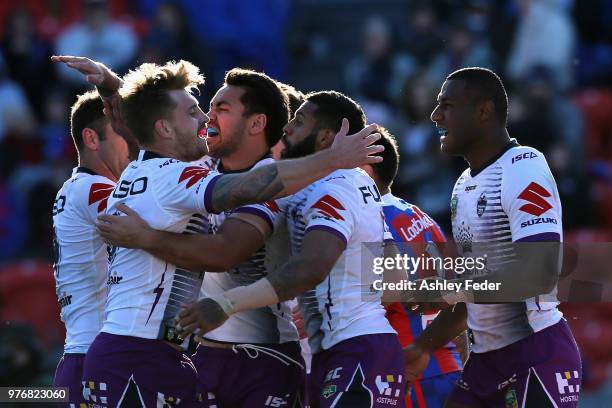 Josh Addo-Carr of the Storm celebrates his try with team mates during the round 15 NRL match between the Newcastle Knights and the Melbourne Storm at...