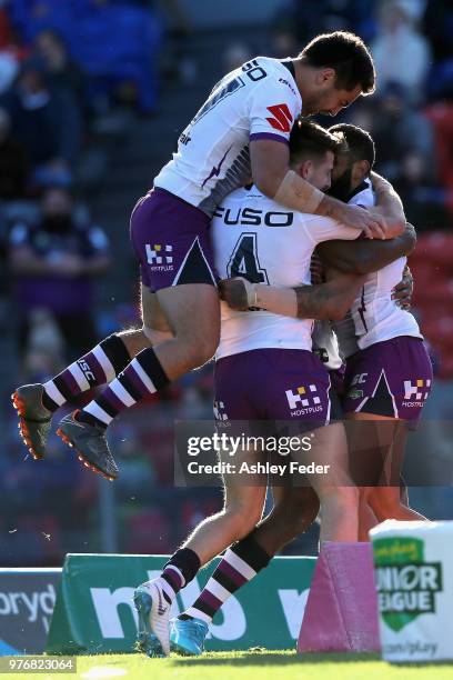 Josh Addo-Carr of the Storm celebrates his try with team mates during the round 15 NRL match between the Newcastle Knights and the Melbourne Storm at...