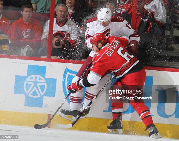 Tim Gleason of the Carolina Hurricanes collides into the boards with Radim Vrbata of the Phoenix Coyotes during a NHL game on March 13, 2010 at RBC...