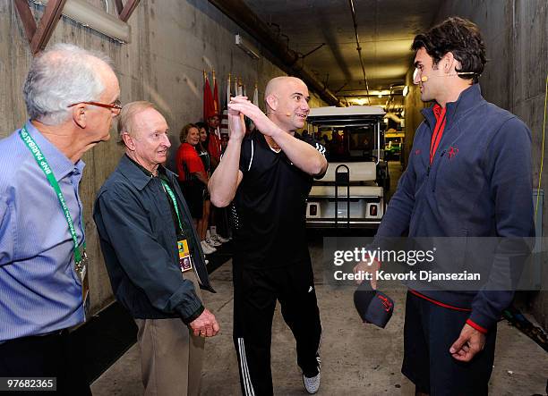 Andre Agassi, speaks with Roger Federer of Switzerland, as tennis legend Rod Laver and Raymond Moore, look on during Hit for Haiti, a charity event...