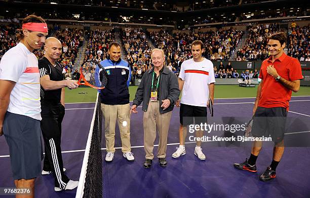 Rafael Nadal of Spain, and his doubles teammate Andre Agassi, chair umpire Mohamed Lahyani, Pete Sampras, Roger Federer of Switzerland look on as...