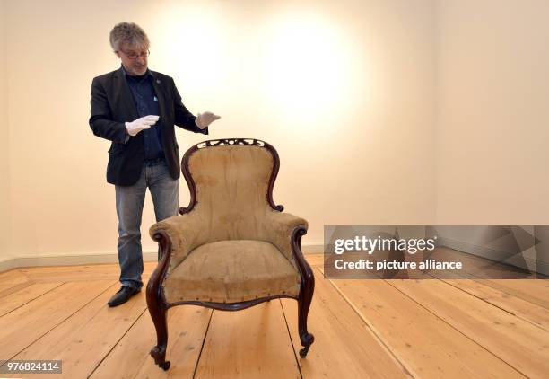 April 2018, Germany, Trier: Art historian Peter Pfister of the Friedrich-Ebert-Foundation presents the armchair of philosopher and economic theorist...