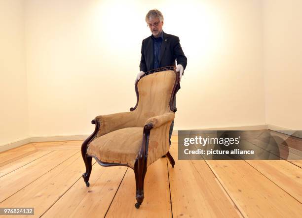 April 2018, Germany, Trier: Art historian Peter Pfister of the Friedrich-Ebert-Foundation presents the armchair of philosopher and economic theorist...