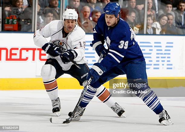 John Mitchell of the Toronto Maple Leafs gets away from Ethan Moreau of the Edmonton Oilers during game action March 13, 2010 at the Air Canada...