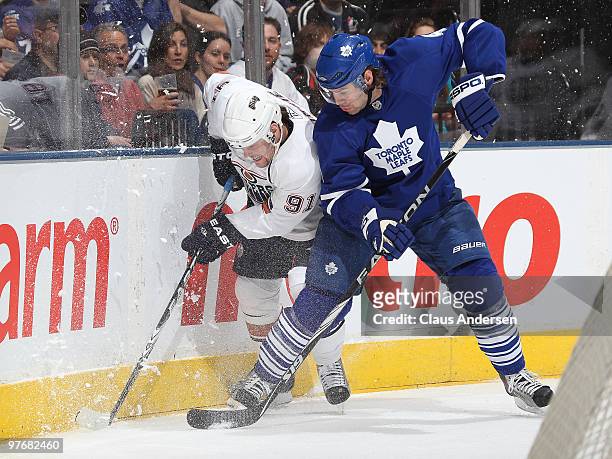 Jeff Finger of the Toronto Maple Leafs battles with Mike Comrie of the Edmonton Oilers in a game on March 13, 2010 at the Air Canada Centre in...