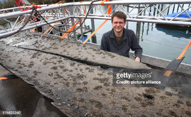 April 2018, Germany, Lindau: Christoph Schmid, who discovered the roughly 3,100-year-old dugout canoe in Lake Constance in 2015, sitting beside the...