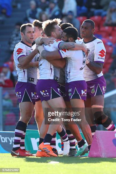 Storm players celebrate a try during the round 15 NRL match between the Newcastle Knights and the Melbourne Storm at McDonald Jones Stadium on June...