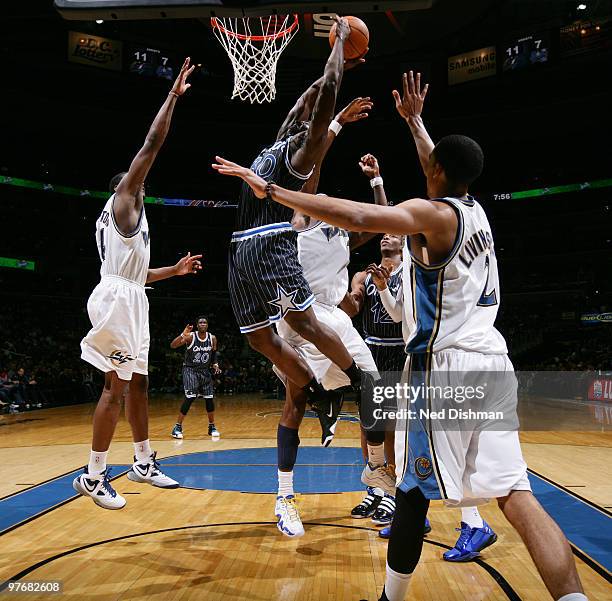 Brandon Bass of the Orlando Magic shoots against Al Thornton and Andray Blatche of the Washington Wizards at the Verizon Center on March 13, 2010 in...