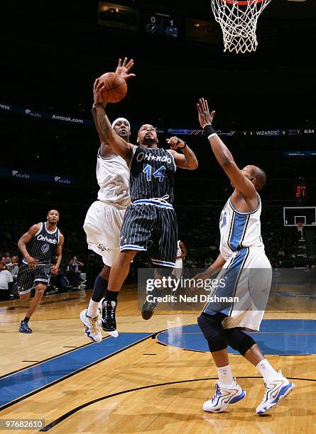 Jameer Nelson of the Orlando Magic shoots against Andray Blatche and Randy Foye of the Washington Wizards at the Verizon Center on March 13, 2010 in...