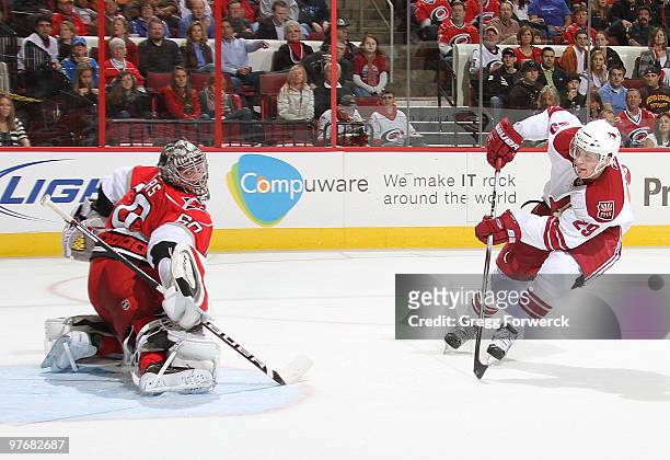 Justin Peters of the Carolina Hurricanes deflects a breakaway shot by Lauri Korpikoski of the Phoenix Coyotes during a NHL game on March 13, 2010 at...