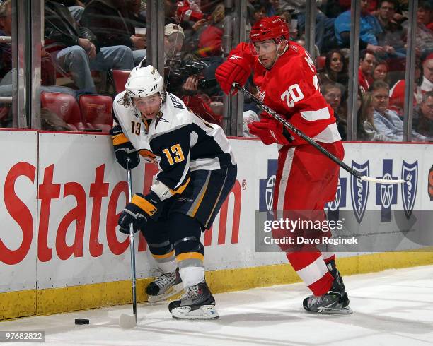 Tim Kennedy of the Buffalo Sabres tries to keep control of the puck away from Drew Miller of the Detroit Red Wings during an NHL game at Joe Louis...