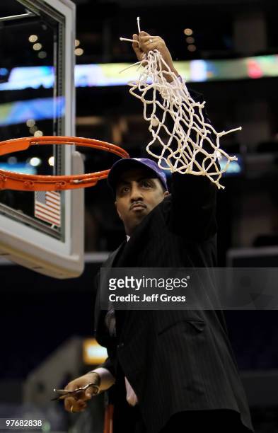 Washington Huskies head coach Lorenzo Romar cuts down the net following his teams victory over the Cal Golden Bears in the championship game of the...