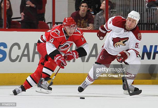 Sergei Samsonov of the Carolina Hurricanes and Derek Morris of the Phoenix Coyotes race to play the puck during a NHL game on March 13, 2010 at RBC...