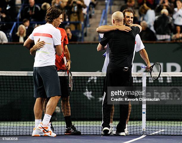 Former tennis player Andre Agassi hugs Pete Sampras as Rafael Nadal of Spain, and Roger Federer of Switzerland, look on at the conclusion of Hit for...