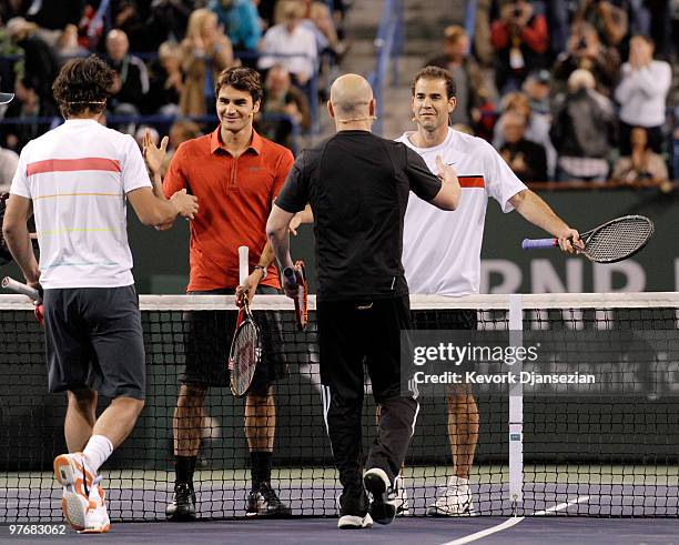 Former tennis player Andre Agassi hugs Pete Sampras as Rafael Nadal of Spain, and Roger Federer of Switzerland, look on at the conclusion of Hit for...