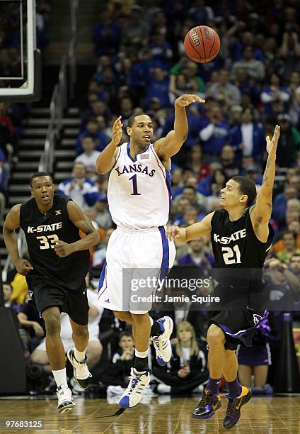 Xavier Henry of the Kansas Jayhawks passes as Wally Judge and Denis Clemente of the Kansas State Wildcats defend during the 2010 Phillips 66 Big 12...