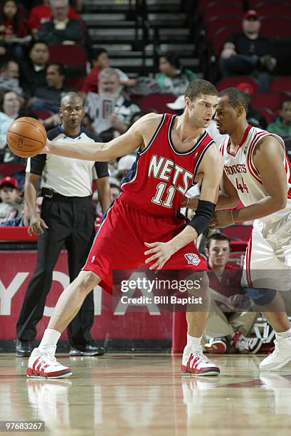 Brook Lopez of the New Jersey Nets drives the ball past Chuck Hayes of the Houston Rockets on March 13, 2010 at the Toyota Center in Houston, Texas....