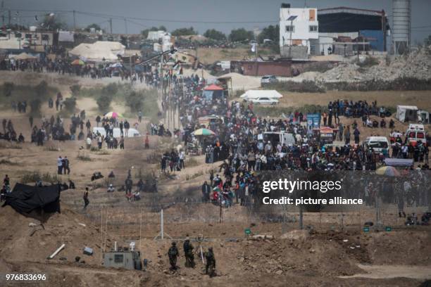 Dpatop - Israeli soldiers take their positions as Palestinian protesters march towards the barriers along the borders between Israel and Gaza Strip,...