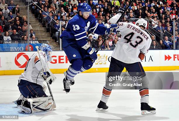 Luca Caputi of the Toronto Maple Leafs jumps out of the way of a shot in front of Jason Strudwick and Devan Dubnyk of the Edmonton Oilers during game...