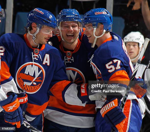 Mark Streit, Sean Bergenheim and Blake Comeau of the New York Islanders celebrate a shorthanded goal by Bergenheim in the third period of an NHL game...