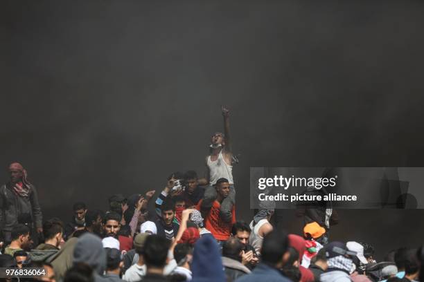 Dpatop - Palestinian protesters shout slogans during clashes with Israeli security forces along the Israel-Gaza border, east of Gaza City, Gaza...