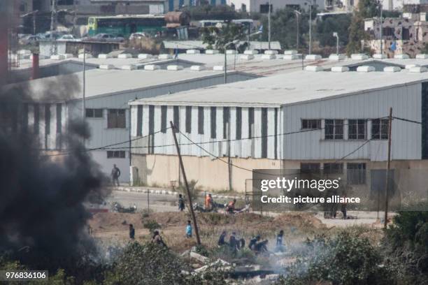 Dpatop - A picture taken from the Israeli side shows Palestinian protesters burning tyres during clashes with the Israeli security forces along the...