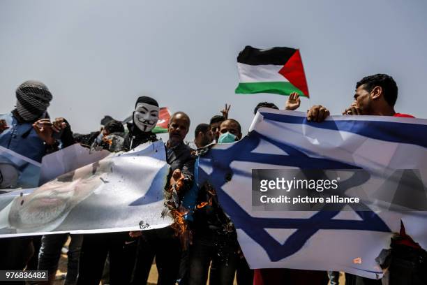 Dpatop - Palestinian protesters set fire to an Israeli flag bearing the picture of Israeli Defence Minister Avigdor Lieberman during clashes with...