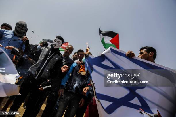 Dpatop - Palestinian protesters set fire to an Israeli flag bearing the picture of Israeli Defence Minister Avigdor Lieberman during clashes with...