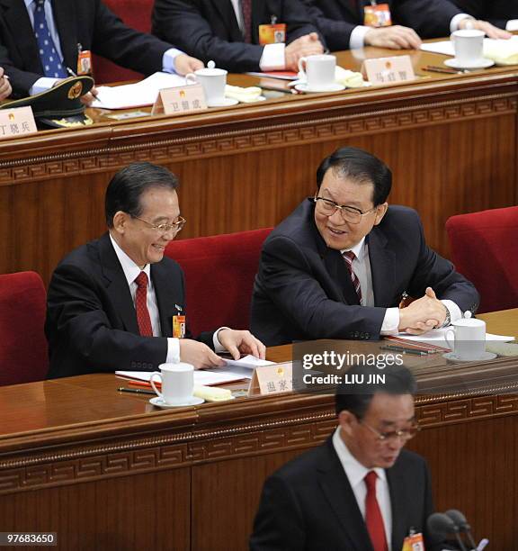 Chinese Premier Wen Jiabao talks to member of Chinese politburo Li Changchun during the closing session of the National People's Congress at the...