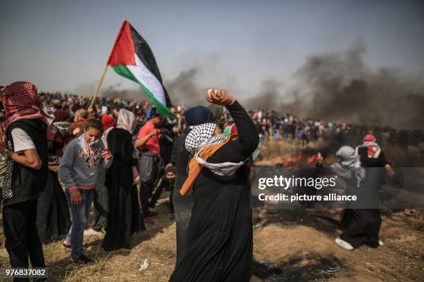 Dpatop - Palestinian protesters hurl stones at Israeli security forces during clashes along the Israel-Gaza border, east of Gaza City, Gaza Strip, 13...