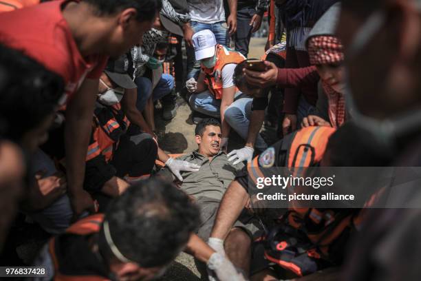 Dpatop - Palestinians help a fellow protester after being injured during clashes with Israeli security forces along the Israel-Gaza border, east of...