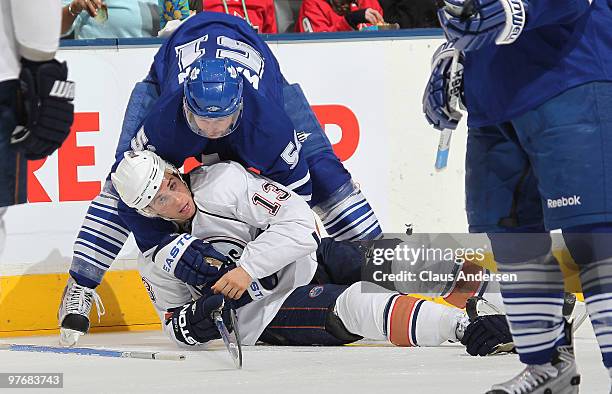 Rickard Wallin of the Toronto Maple Leafs holds Andrew Cogliano of the Edmonton Oilers down on the ice in a game on March 13, 2010 at the Air Canada...