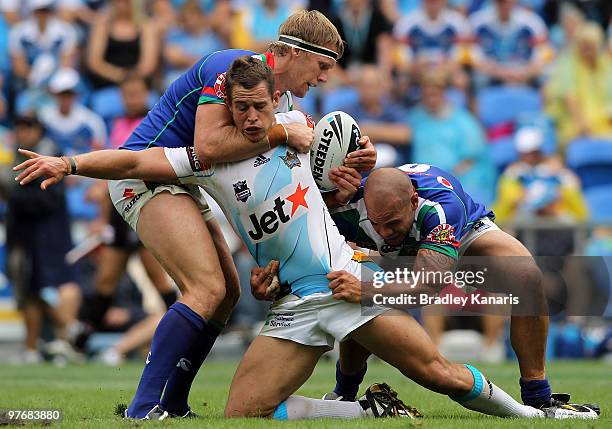 Ashley Harrison of the Titans is tackled during the round one NRL match between the Gold Coast Titans and the Warriors at Skilled Park on March 14,...
