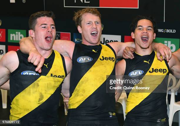 Jack Higgins, Josh Caddy and Daniel Rioli of the Tigers sing the song in the rooms after winning the round 13 AFL match between the Geelong Cats and...