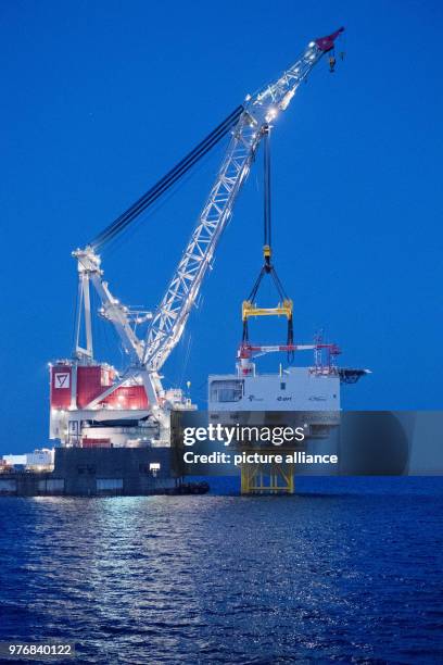April 2018, Germany, Sassnitz: The 4,000 tons weighing transformer platform is being mounted with the help of crane ship 'Oleg Strashnov' at the...