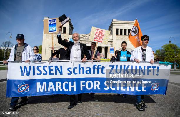 April 2018, Germany, Munich: Protestors start their march at the Koenigsplatz and carry a banner reading 'Wissen schafft Zukunft! March for Science'...