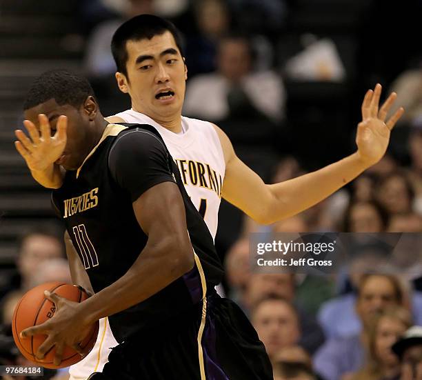 Matthew Bryan-Amaning of the Washington Huskies drives to the basket while being defended by Max Zhang of the Cal Golden Bears in the first half...