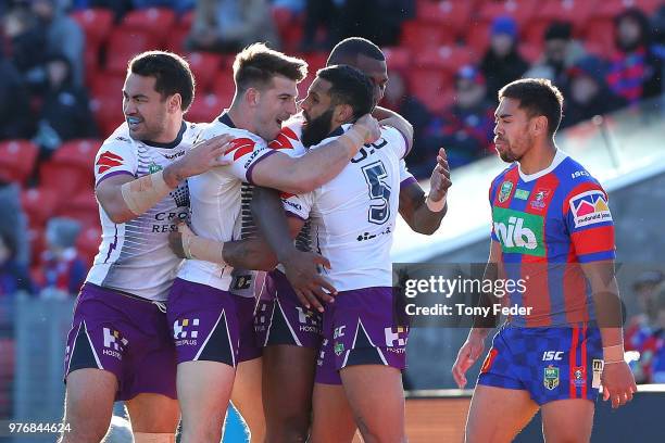 Josh Addo-Carr of the Storm celebrates a try with team mates during the round 15 NRL match between the Newcastle Knights and the Melbourne Storm at...