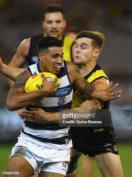 Tim Kelly of the Cats is tackled by Jayden Short of the Tigers during the round 13 AFL match between the Geelong Cats and the Richmond Tigers at...