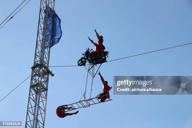 April 2018, Germany, Drognitz: High-wire artists of the 'Geschwister Weisheit' are on a motorbike and drive across the Hohenwarte reservoir on wire...