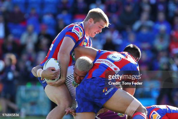Nelson Asofa-Solomona of the Storm is tackled during the round 15 NRL match between the Newcastle Knights and the Melbourne Storm at McDonald Jones...