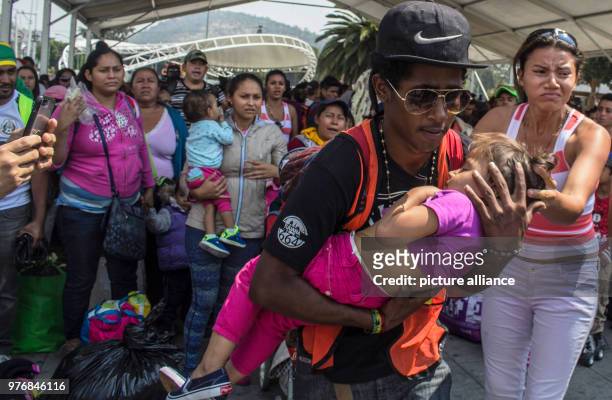 April 2018, Mexico, Mexico-City: A young man carries a child in his arms on their way with other Central American migrants through Mexico. Numerous...