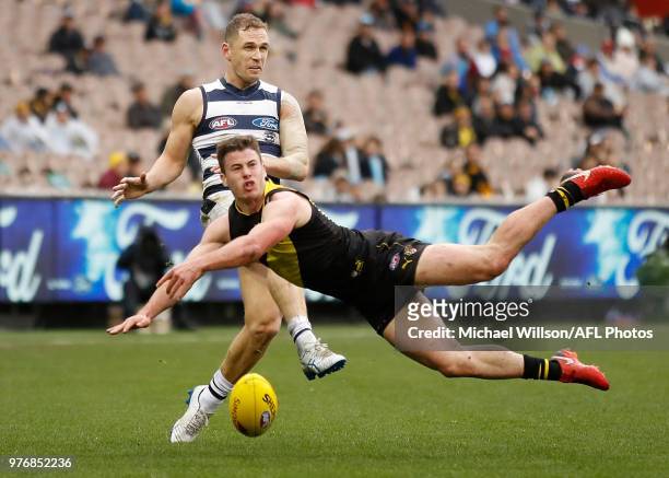 Joel Selwood of the Cats has his kick smothered by Jack Higgins of the Tigers during the 2018 AFL round 13 match between the Geelong Cats and the...