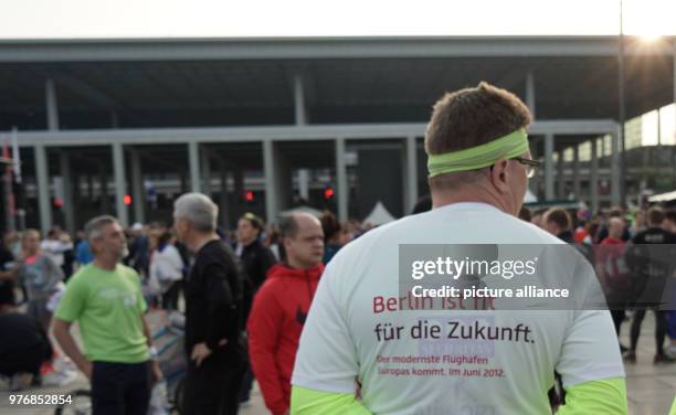April 2018, Germany, Berlin-Schoenefeld: A runner participates in the 12th Airport Night Run and wears a shirt which reads 'Berlin ist fit für die...