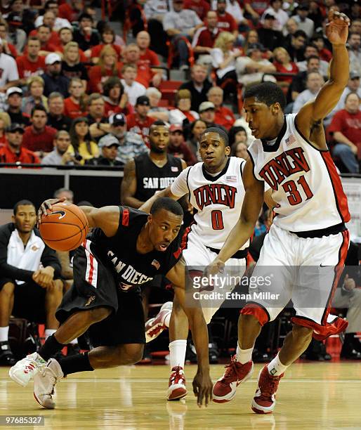 Gay of the San Diego State Aztecs tries to get around the defense of Oscar Bellfield and Justin Hawkins of the UNLV Rebels during the championship...